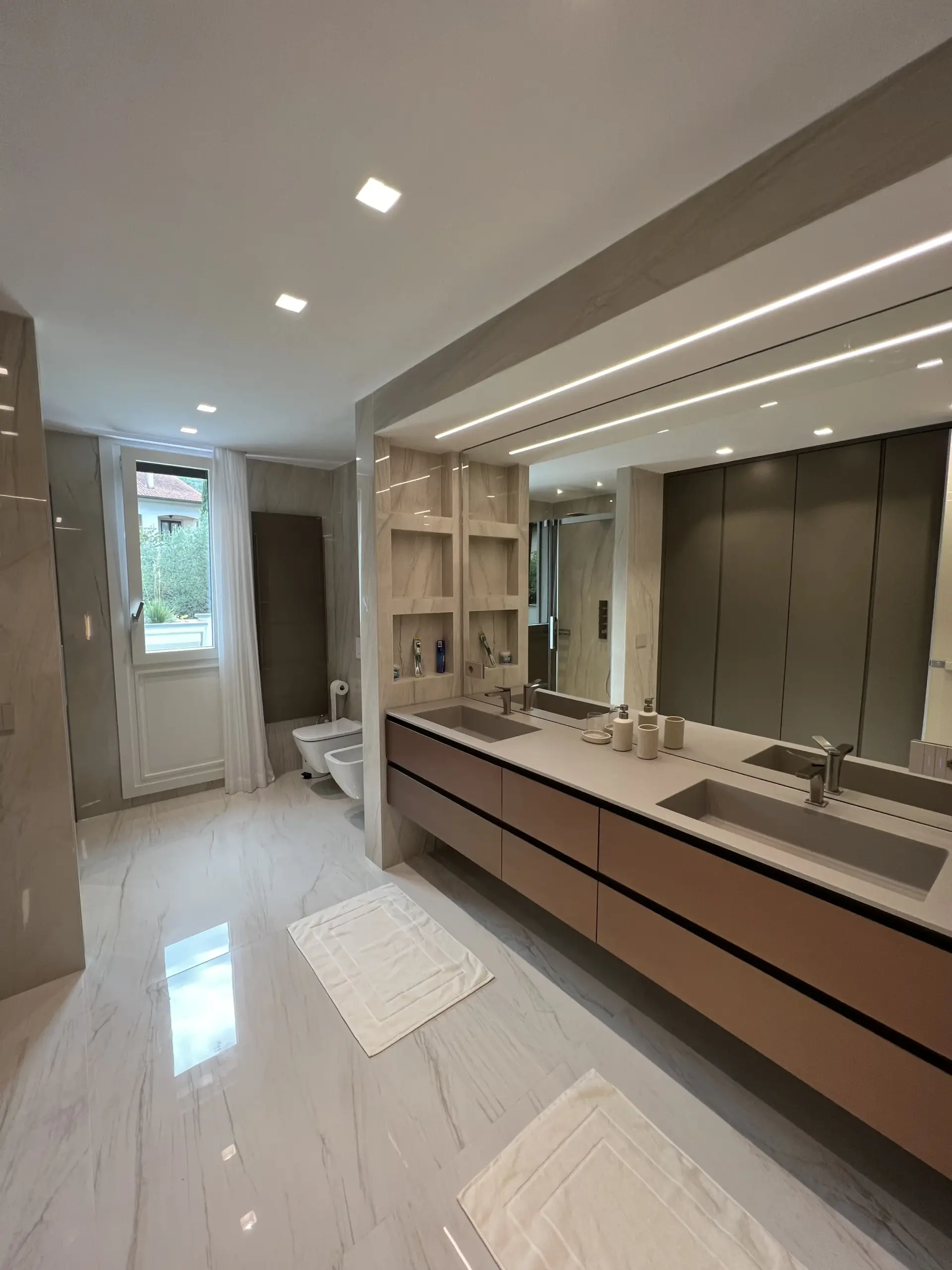 Ampio ed elegante bagno moderno con doppio lavabo, frutto del completo rifacimento degli impianti idraulici e della cura per i dettagli d'arredo